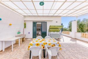 a patio with a table with sunflowers on it at Villetta Relax in Castrignano del Capo +14 photos