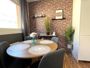 mesa de comedor con sillas y pared de ladrillo en Urban I Modern I Stylish I Smart, en Viena