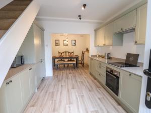 een keuken met witte kasten en een houten vloer bij Ribble Cottage in Settle