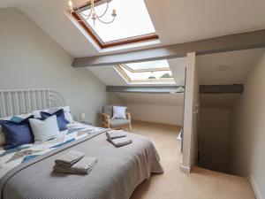 een slaapkamer met een bed en een dakraam bij Ribble Cottage in Settle