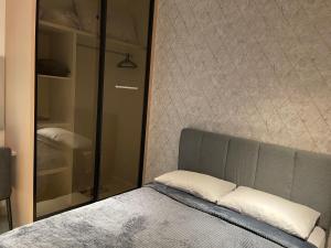 a bedroom with a bed and a glass cabinet at One Majestic Ipoh - 3 Bedroom Apt For Family of 5 in Ipoh +8 photos