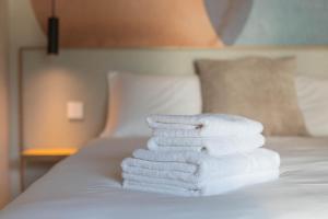 a pile of towels stacked on a bed at Palanga Studios in Palanga