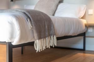 a blanket on the end of a bed at Palanga Studios in Palanga