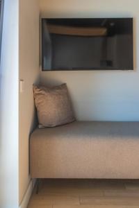 a pillow sitting on a couch with a flat screen tv at Palanga Studios in Palanga