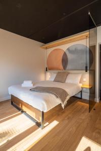 a bedroom with a bed with a painting on the wall at Palanga Studios in Palanga