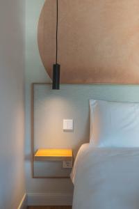 a bedroom with a bed and a nightstand with a light at Palanga Studios in Palanga