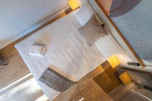 an overhead view of a bed with white sheets and pillows at Palanga Studios in Palanga