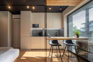a kitchen with a table and two stools at Palanga Studios in Palanga