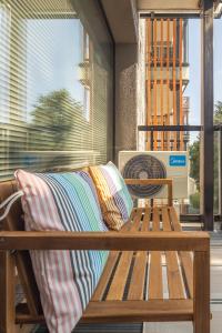 a wooden bench sitting on a porch with a fan at Palanga Studios in Palanga