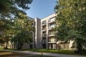 an apartment building with trees in front of it at Palanga Studios in Palanga