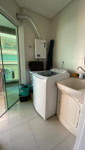 a kitchen with a washing machine and a sink at Quarto Suíte em apto compartilhado com anfitrião Mandi a 250m do Mar in Itapema
