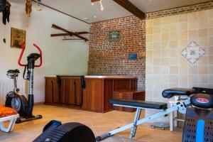 una habitación con un gimnasio con equipamiento de ejercicio. en L'Etape Normande, en Montroty