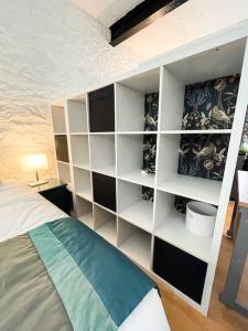 una camera con un letto e una mensola bianca per libri di The Garden Flat a Plymouth