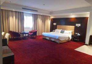 a hotel room with a large bed and a desk at ارجان سويت 2 in Jeddah