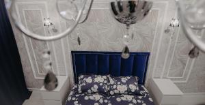 a bedroom with a bed with a blue head board at VIP апартаменты однокомнатная квартира in Uralsk
