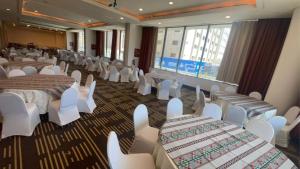 einen Bankettsaal mit Tischen und weißen Stühlen in der Unterkunft Holiday Inn Olaya, an IHG Hotel in Riad