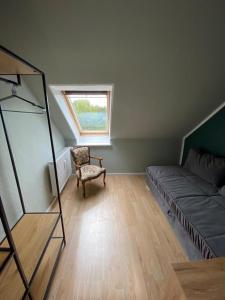 um quarto com uma cama, uma cadeira e uma janela em DG Apartament em Bersenbrück