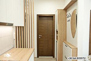 een keuken met een houten deur in een kamer bij AquaVista Apartman in Jagodina