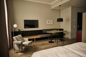 a hotel room with a bed and a table and chair at Melter Hotel & Apartments - a Neighborhood Hotel in Nuremberg