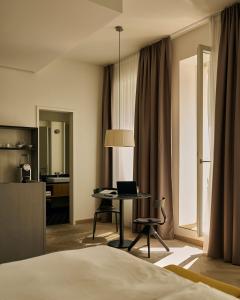 a hotel room with a bed and a table with a laptop at Melter Hotel & Apartments - a Neighborhood Hotel in Nuremberg