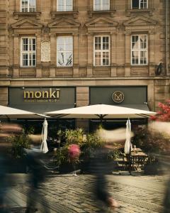 un bâtiment avec des parasols en face d'un restaurant dans l'établissement Melter Hotel & Apartments - a Neighborhood Hotel, à Nuremberg