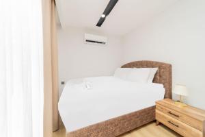 a bedroom with a white bed and a chair at Modern Flat w Balcony 10 min to Beach in Antalya in Antalya