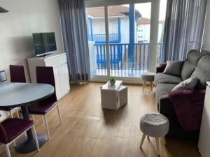 una sala de estar con un sofá y una mesa en Appartement Résidence Fort Socoa, en Urrugne