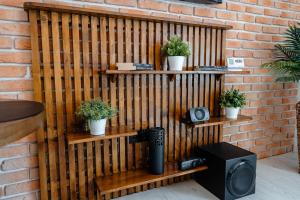 eine Holzwand mit Regalen mit Pflanzen und einem Lautsprecher in der Unterkunft Holiday in Alba Iulia