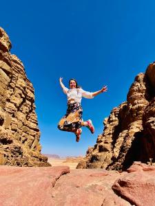 una persona saltando en el aire sobre algunas rocas en Marina Wadi Rum Camp en Disah