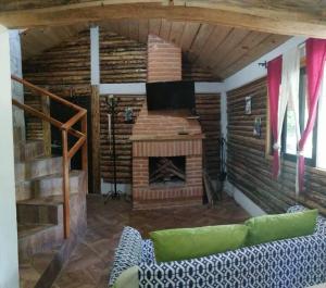 聖克里斯托瓦爾－德拉斯卡薩斯的住宿－LIN K'AK' Cabaña San Cristobal de las casas，带沙发和壁炉的客厅