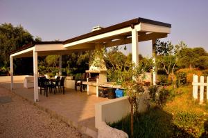 a pavilion with a table and chairs in a garden at PM Villa Tania Guest House in Alghero