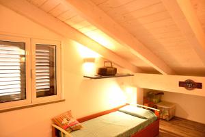 Camera mansardata con letto e finestra. di PM Villa Tania Guest House ad Alghero