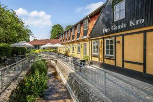 a building with a bridge in front of it at Den Gamle Kro Hornslet in Hornslet