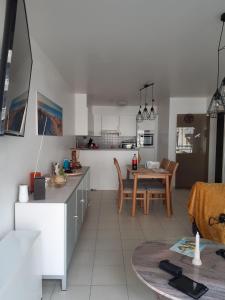 cocina y sala de estar con mesa y sillas en Residentie Lumina en Middelkerke