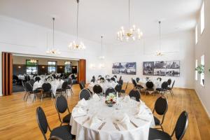 une salle de banquet avec des tables blanches, des chaises et des lustres dans l'établissement Den Gamle Kro Hornslet, à Hornslet