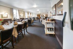 une salle à manger avec des tables et des chaises dans un restaurant dans l'établissement Den Gamle Kro Hornslet, à Hornslet