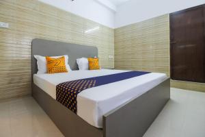 a bedroom with a bed with orange and blue pillows at Flagship Jp Residency in Singapperumālkovil