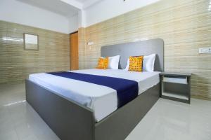 um quarto com uma cama grande com almofadas azuis e amarelas em Flagship Jp Residency em Singapperumālkovil