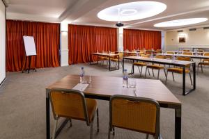 a conference room with tables and chairs and red curtains at GINGER Hotel in Tbilisi City