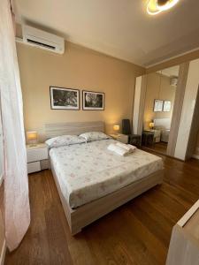 een slaapkamer met een groot bed met 2 tafels en een spiegel bij T-Rooms in Cagliari