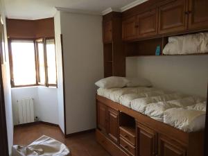 a small room with two beds and a window at Apartamento Playa de Usil in Mogro