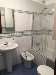 a bathroom with a sink and a shower and a toilet at Apartamento Playa de Usil in Mogro
