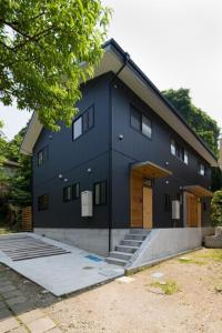 a black house with a lot of windows at ＡＴＴＡ ＨＯＴＥＬ ＫＡＭＡＫＵＲＡ / Vacation STAY 76829 in Kamakura