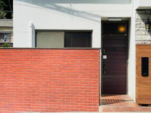 een huis met een stenen muur en een paarse deur bij ＡＴＴＡ ＨＯＴＥＬ ＫＡＭＡＫＵＲＡ - Vacation STAY 33593v in Kamakura