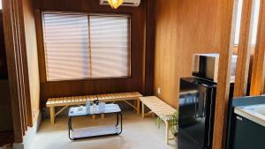 a kitchen with a bench and a table and a refrigerator at ＡＴＴＡ ＨＯＴＥＬ ＫＡＭＡＫＵＲＡ - Vacation STAY 33593v in Kamakura