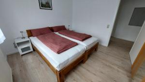 um quarto com uma cama com um cobertor vermelho em Appartement, komplett saniert, 47 m², mit Terrasse und Gartennutzung em Meinerzhagen