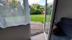 uma porta de vidro deslizante com vista para um quintal em Appartement, komplett saniert, 47 m², mit Terrasse und Gartennutzung em Meinerzhagen
