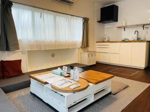 a living room with a coffee table and a kitchen at ＡＴＴＡ ＨＯＴＥＬ ＫＡＭＡＫＵＲＡ - Vacation STAY 63328v in Kamakura