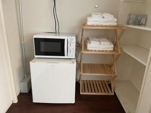 a microwave on top of a refrigerator in a kitchen at ＡＴＴＡ ＨＯＴＥＬ ＫＡＭＡＫＵＲＡ - Vacation STAY 63328v in Kamakura