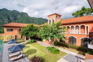 an exterior view of a building with a yard at Locanda Villanova Bed & Breakfast in Pak Chong